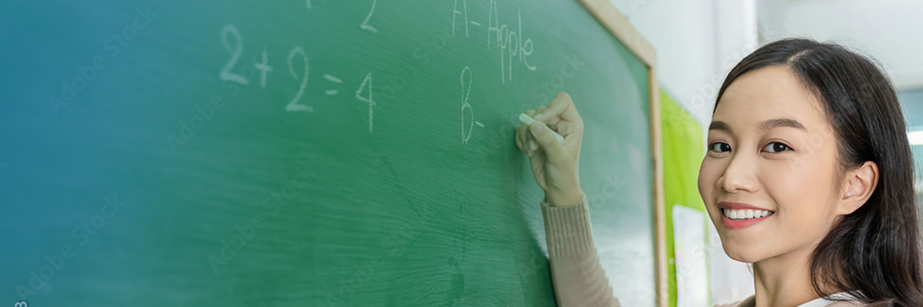 teacher writing on chalkboard 